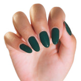 Hand with dark green nail polish on a white background